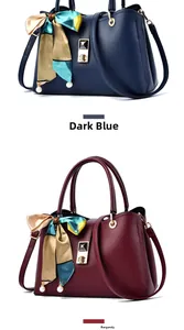 Detail view of lychee leather handbags in navy blue and burgundy with silk scarf and pearls