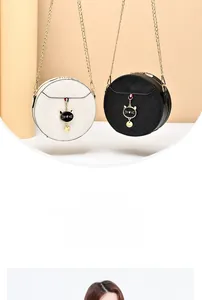 Detail of round quilted leather bags with cat pendants and gold chain straps