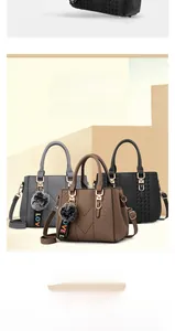 Detail of PU leather handbag texture with V-shaped stitching and plush pom-pom charm
