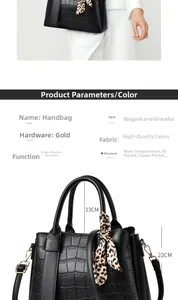 Detail of black faux crocodile leather handbag with leopard scarf and gold hardware