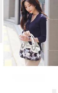 Close-up of women's soft leather floral handbag with silver metal buckles for daily use