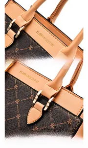 Detail shot of the gold logo print and textured faux leather stitching on the handbag
