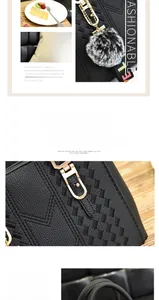 Detail of black PU leather handbag featuring embroidery stitching and a gray fur pom pom