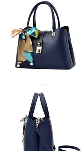Macro detail of navy blue handbag featuring leather texture, metal lock, and silk scarf with pearls
