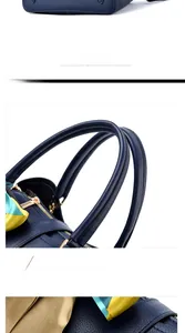 Detail of dark blue leather handbag showing bottom rivets, soft handle and decorative scarf