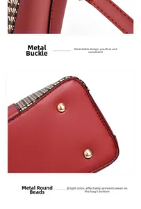 Detail of red leather bag with golden hardware hooks and protective metal base feet