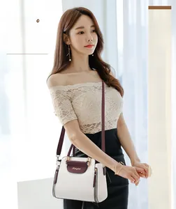 Detail of multi-color crossbody bag with cream body, red flap and gold-tone zippers