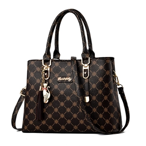 Classic patterned handbag with gold hardware and tassel charm, shown in a front view