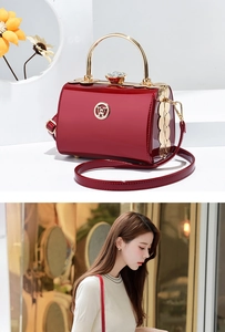 Detail of dark red patent leather handbag with gold W logo and crystal clasp