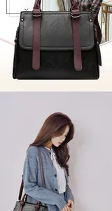 Detail of lychee pattern leather handbag with contrast burgundy handle and shoulder strap