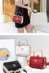Close-up of metallic handle and crystal buckle on glossy leather barrel handbag