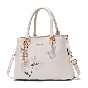 Off-white embroidered handbag with floral patterns and pearl bow charm accessory
