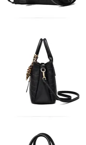 Side view of black stone pattern handbag with leopard print scarf and gold hardware