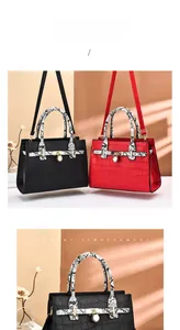 Detail of crocodile-textured leather bags with snake-skin handles and gold padlock hardware
