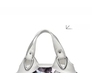 Detail of white tote bag top handle with silver metal buckles and floral pattern
