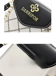 Détails du motif matelassé et de la poignée en perles sur le sac de téléphone noir et blanc