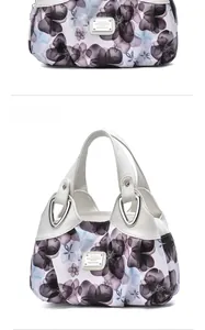 Macro detail of floral handbag handle with silver triangular hardware and brand logo
