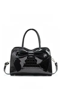 Detailed front view of black patent leather handbag with crocodile pattern and bow