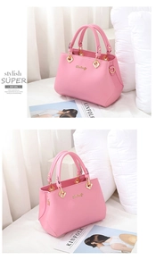 Detailed view of pink bridal leather handbag with gold metallic logo and dual handles