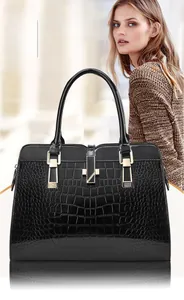 Détail d'un sac à main noir texture crocodile brillant avec fermoir en métal doré chic