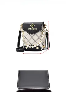 Détail du mini sac bandoulière avec rabat noir, logo doré et poignée en perles