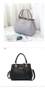 Detail of elegant top-handle bag with gold hardware and detachable shoulder strap