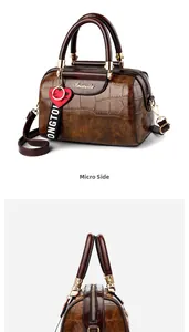 Detailed views of brown faux-crocodile Boston bag with heart charm and gold zipper details