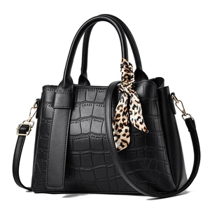 Elegant black stone patterned handbag with leopard print scarf and golden hardware