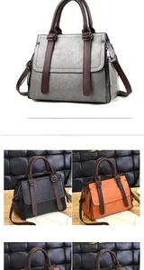 Close-up of retro litchi grain handbag featuring top handles and metal zipper details