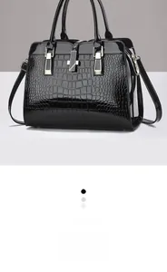 Vue détaillée du cuir verni noir à motif crocodile avec des finitions dorées élégantes