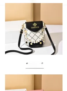 Détail d'un mini sac bandoulière en cuir noir et blanc avec une poignée en perles