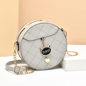 Chic grey round quilted crossbody bag with gold chain and cute cat charm pendant