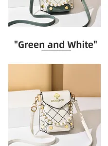Détail du sac de téléphone avec poignée en perles et cuir contrasté vert et blanc