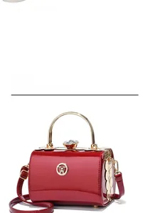 Detail of red patent leather handbag with gold ring handle and jeweled clasp