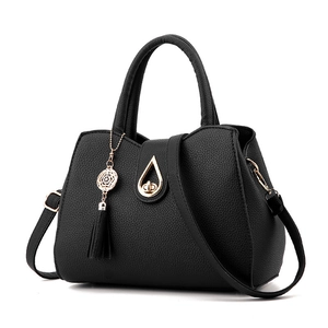 Elegant black lychee grain handbag with gold clasp and tassel detail on white background