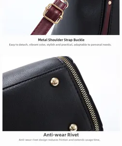 Detail of gold hardware buckle with burgundy strap and protective rivets on black leather bag
