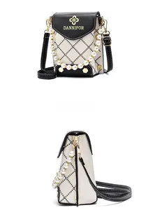 Détail du mini sac bandoulière avec motif matelassé, chaîne perlée et logo fleur dorée