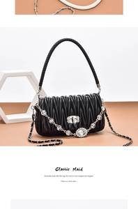 Close-up of black matelassé pleated leather texture with crystal metal lock detail