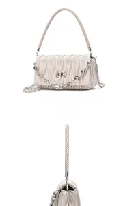 Close-up of cream quilted handbag featuring metal twist lock and rhinestone chain detail