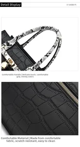 Detail view of the black tote bag featuring snakeskin handles and golden hardware clasp