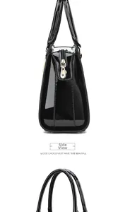 Détail de côté du sac à main noir brillant à motif crocodile avec fermeture dorée