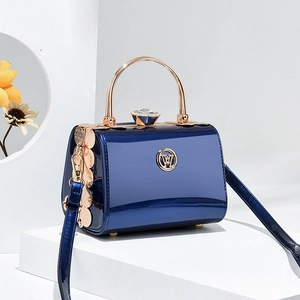 Glossy navy leather handbag with golden circular handle and elegant rhinestone clasp