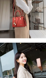 Detail of red lychee grain leather handbag featuring gold hardware and a bell charm