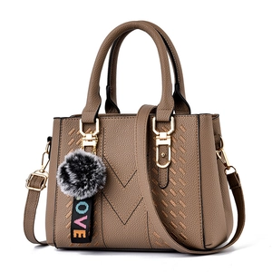 Braune Handtasche aus Litchi-Leder mit V-Naht und grauem Kunstpelz-Bommel-Anhänger