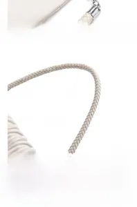 Detail of silver hardware clasp and braided leather handle on beige square handbag