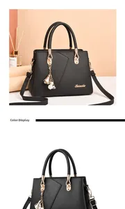 Detail of black lychee grain leather handbag with gold logo and pearl flower charm