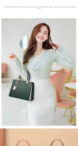Detail view of large green handbag with multi-compartment interior and gold hardware
