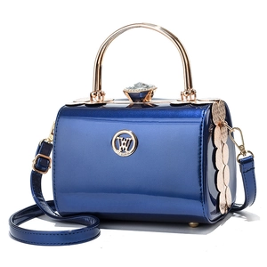 Blue patent leather handbag with gold metal top handle and jewel clasp shown in center view
