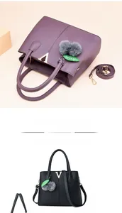 Makroaufnahme von Handtaschen mit Litschi-Struktur, goldenem V-Logo und Pelzbommel