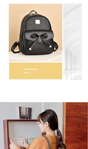 Détail d'un sac à dos en cuir PU noir avec un nœud décoratif et une plaque métallique